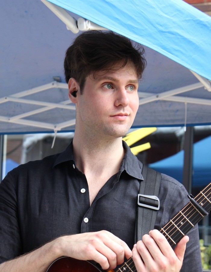 Zac Graves holding an acoustic guitar